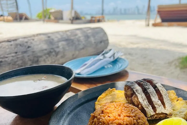 Plate of fried fish, rice, and plantains served at a beach restaurant